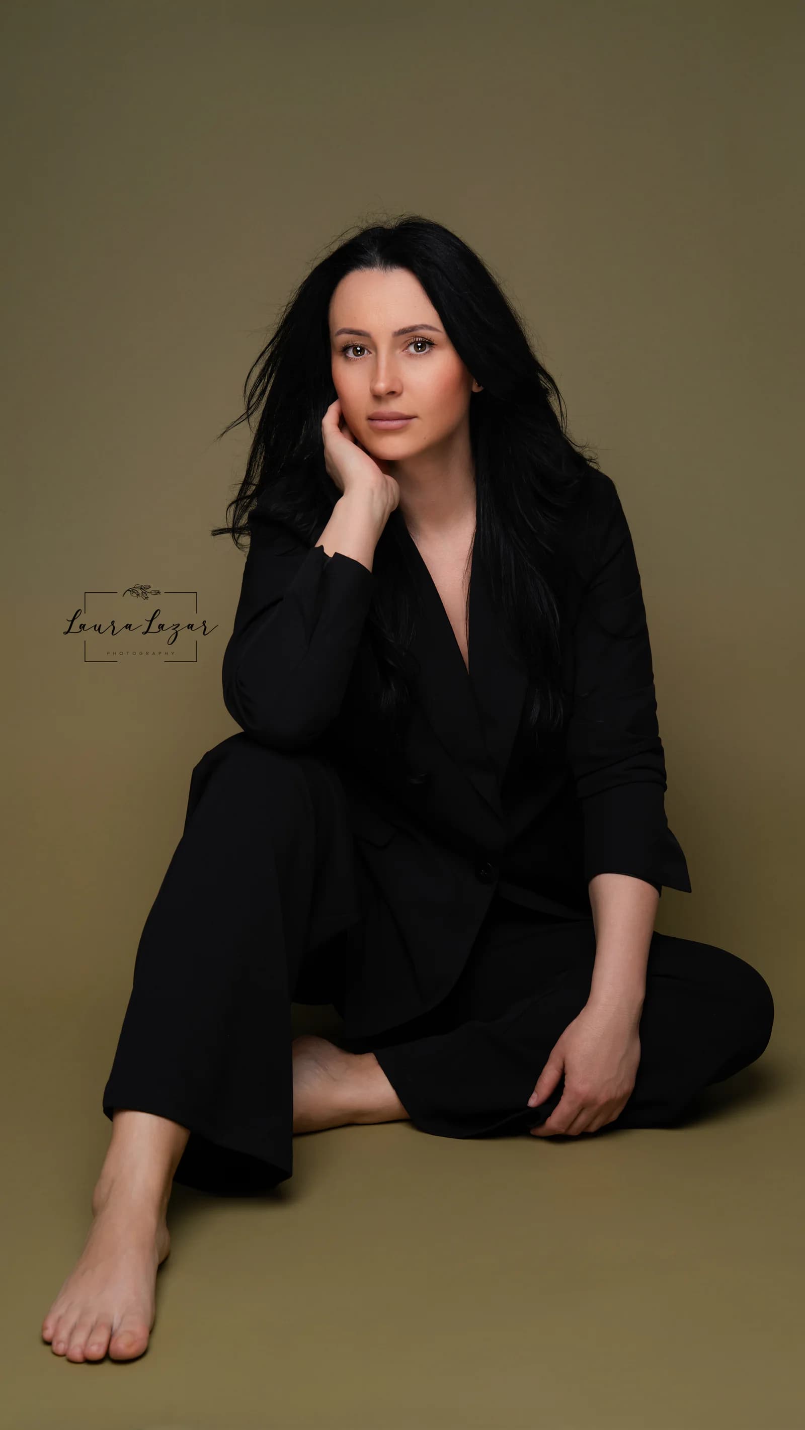 Portret apropiat de branding într-un costum negru, pe fundal oliv.