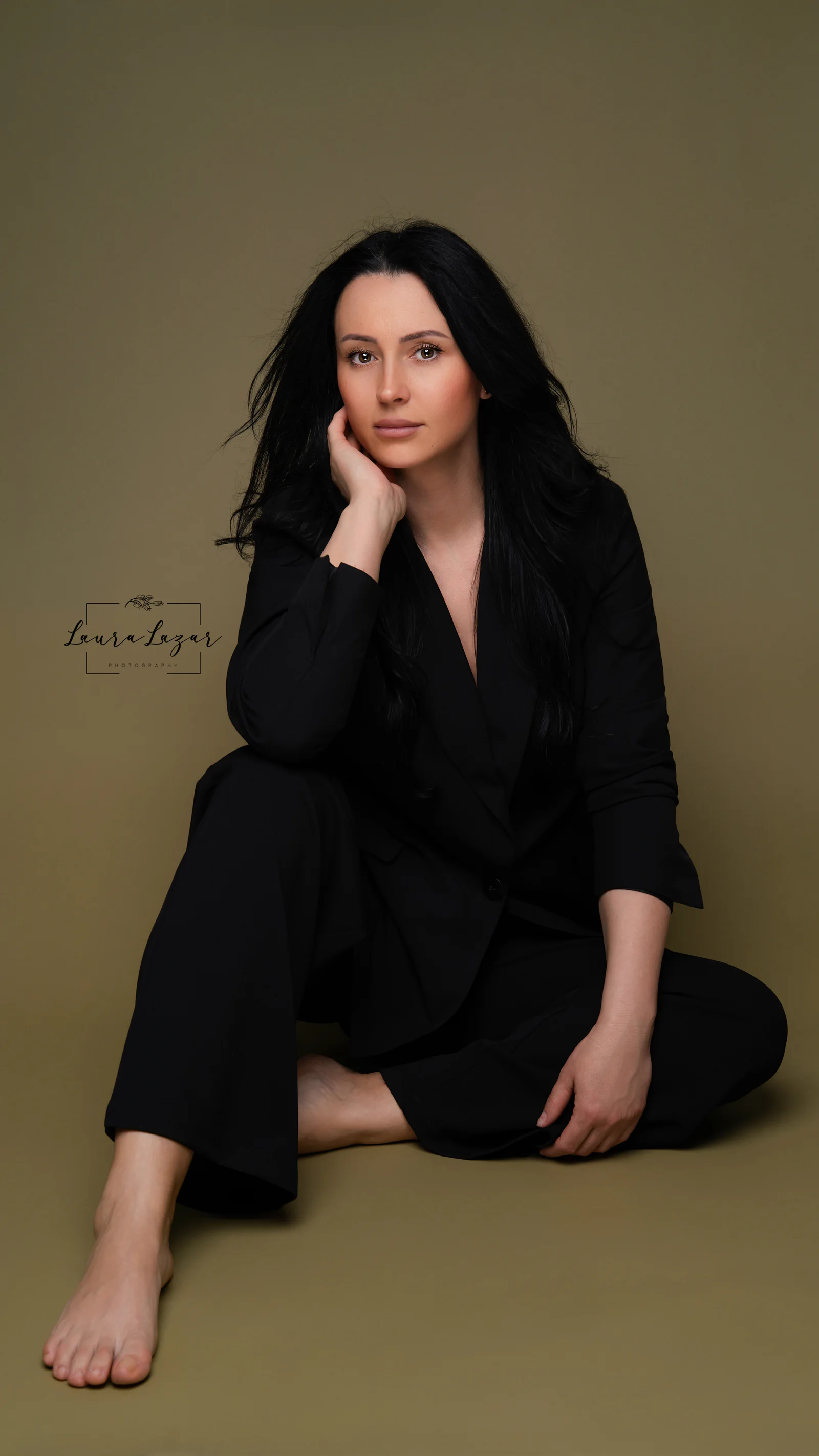 Portret apropiat de branding într-un costum negru, pe fundal oliv.